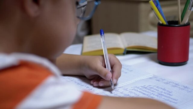 Schoolboy Writes with Left Hand in Notebook, Using Handle. Online Home Training