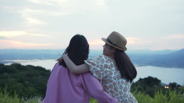 Group of friends watching the evening sunset view and hug your neck and have fun together.