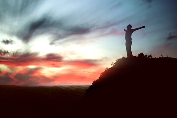 Silhouette of businessman raised hands and praying to god