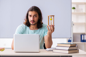 Young male student preparing for exams in time management concep