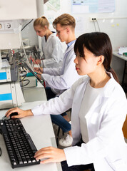 Obraz premium Young Caucasian and Asian students engaged in research at chemical lab