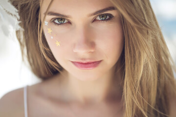 Attractive beauty woman face with star make up freckles. Portrait of a girl. High quality photo.