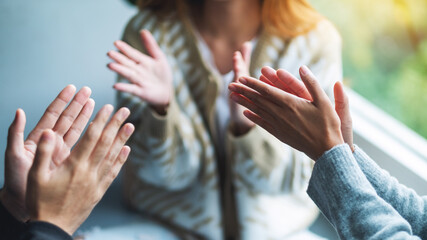 A group of young people clapping hands while sitting together