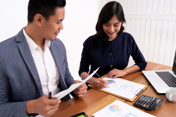 portrait of business partner calculating her business profits and working on a laptop. On modern office desk