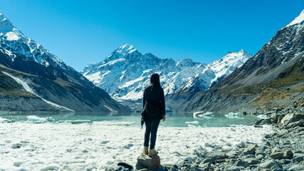 A woman stand alone to Mt. cook peak, Tasman lake, in Newzealand