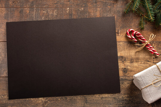 Christmas mockup. Christmas greeting card or photo frame over wooden table with black blank paper