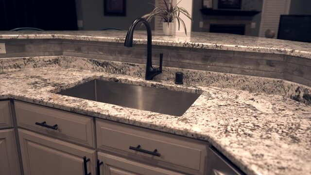 Contemporary kitchen cabinet design with counter top made of granite stone, under mount sink and faucet. Kitchen countertops are in white and gray colors.