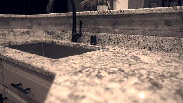 Kitchen granite or quartz countertops in slow motion prospective view. Low surface shot of counter top with cinematic look.