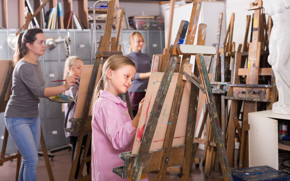Young female teenagers practicing their skills during painting class at art studio.