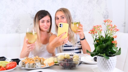 Two happy friends sharing online content using smartphone at home, selective focus