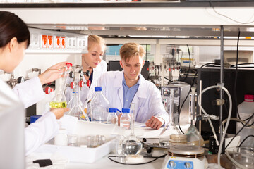 Obraz premium Portrait of male and female scientists in white coats working at biochemical laboratory