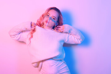 Girl in a white sweater in neon light. Masked woman, fashion photo.