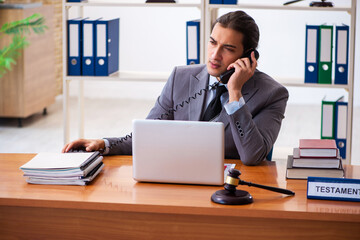 Naklejka premium Young male lawyer sitting in the office