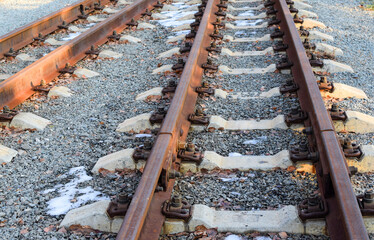 Image of an empty railroad track stretching far away. Narrow gauge railway.