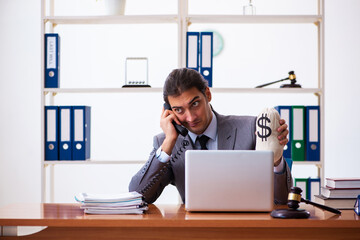 Young male lawyer sitting in the office