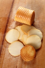 Fototapeta na wymiar Smoked cheese slices on wooden cutting board