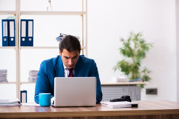 Fototapeta premium Young male employee working in the office