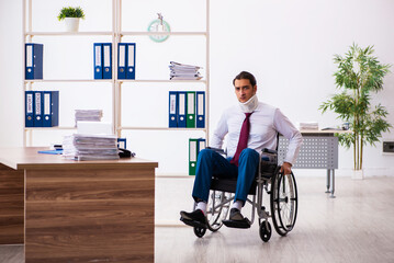 Neck injured young male employee in wheel-chair at workplace