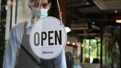 Reopen. waitress man turning open sign board reopen after coronavirus quarantine is over in modern cafe coffee shop ready to service, cafe restaurant, small business owner, food and drink concept - Powered by Adobe