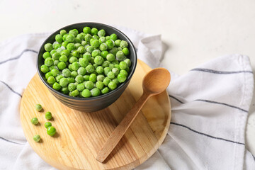 Bowl with frozen green peas on table
