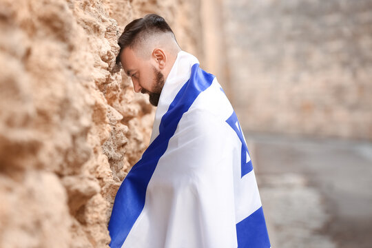 Man with the flag of Israel near the Wailing Wall