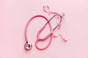 Pink ribbon and stethoscope on color background. Breast cancer awareness concept