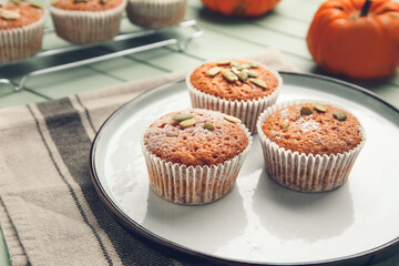 Plate with tasty pumpkin muffins on table
