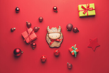 Tasty cookie in shape of bull and Christmas decor on color background