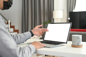Cropped shot man freelancer working with computer laptop in living room at home.
