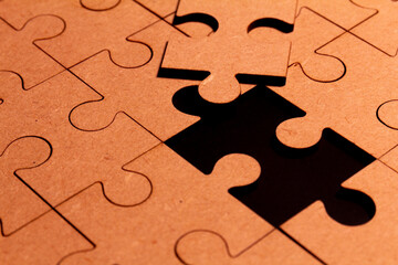 Close up view of a brown puzzle with one piece missing