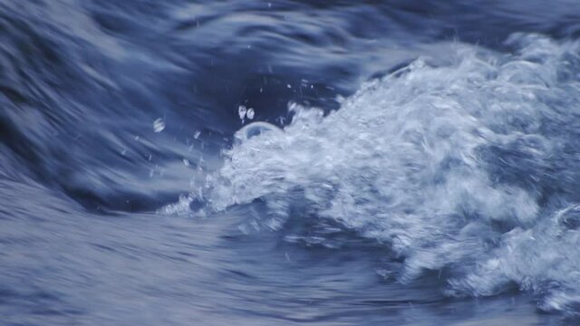 Detail of splashing fast river, slow motion (100fps).