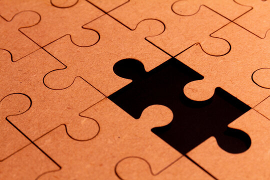 Close up view of a brown puzzle with one piece missing
