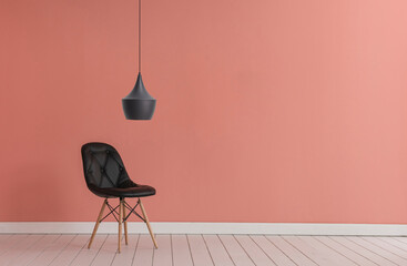 Pink wall background with black chair and lamp style.