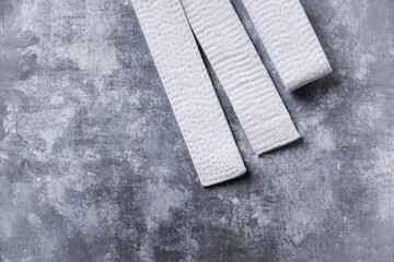 White karate belt on rustic wooden background. Top view.  © Eugeniusz Dudziński