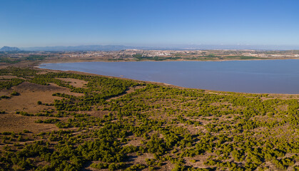 The western part of the La Mata lagoon north of the Spanish city of Torrevieja. The city of Montesinos can be seen in the background. Mountains are on the horizon.