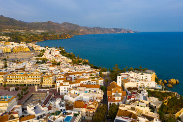 Panoramic aerial view of Nerja city by Mediterranean coast on sunny day, Costa del Sol, Spain