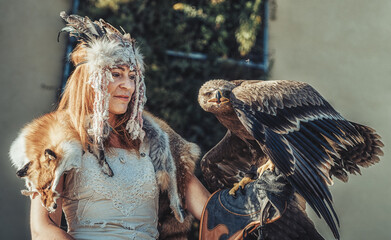 beautiful shamanic woman with eagle in the nature.