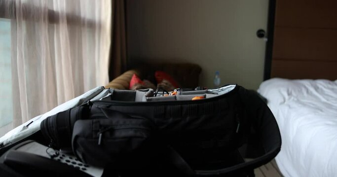man packing camera bag luggage