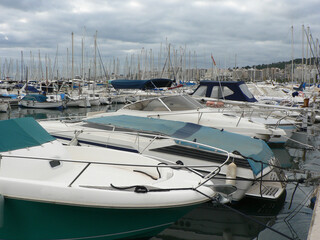 Boats in a yacht club in the Mediterranean sea, island of Mallorca, Spain. Yachts moored in the port on a cloudy day.