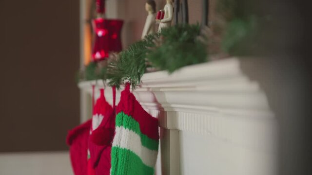 Christmas stockings hang from a decorated mantel