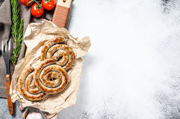 Traditional German pork spiral grilled sausages. Gray background. Top view. Copy space