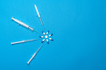 Top view of Pills and Syringes On blue background with copy space