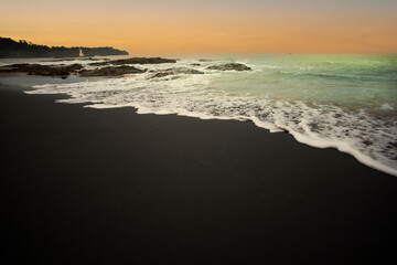 Black sand beach with gentle wave