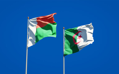 Beautiful national state flags of Madagascar and Algeria together at the sky background. 3D artwork concept.