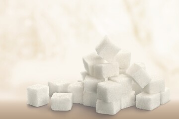 White cubes of sugar on a blur background