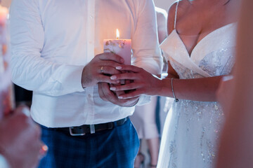 bride and groom holding a candle at the wedding