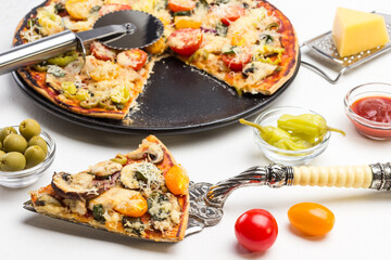 Slice of pizza on scoop. Ready pizza on black plate.