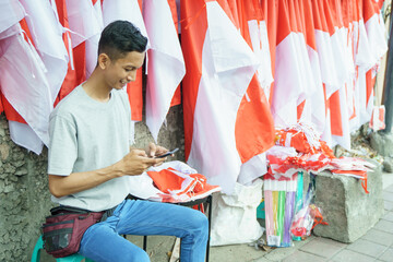 portrait of a young man selling flags taking orders from a telephone