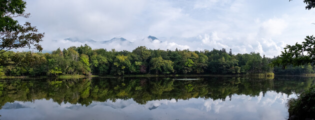 Panoramic view of forest reflecting in one of Shiretoko Five Lakes