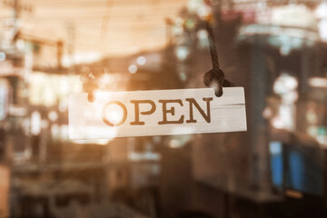 A business sign that says ‘Open’ on cafe or restaurant hang on door at entrance.